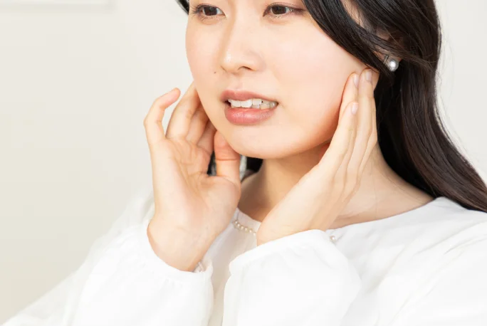 両手で頬を押さえる女性
